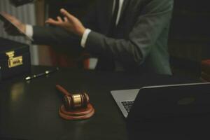 Business and lawyers discussing contract papers with brass scale on desk in office. Law, legal services, advice, justice and law concept picture with film grain effect photo