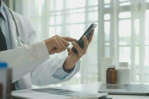 Doctor sitting at desk and writing a prescription for her patient photo