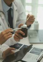 Doctor sitting at desk and writing a prescription for her patient photo