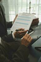 Business and lawyers discussing contract papers with brass scale on desk in office. Law, legal services, advice, justice and law concept picture with film grain effect photo