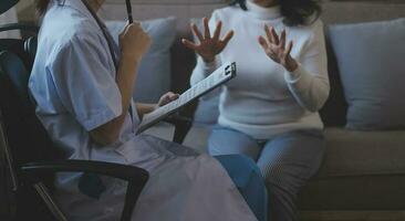 mental salud consejero. joven mujer durante terapia sesión hablando con un psicólogo en el oficina. foto