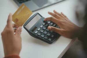 Close up female hands holding credit card and smartphone, young woman paying online, using banking service, entering information, shopping, ordering in internet store, doing secure payment photo