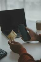 Close up female hands holding credit card and smartphone, young woman paying online, using banking service, entering information, shopping, ordering in internet store, doing secure payment photo