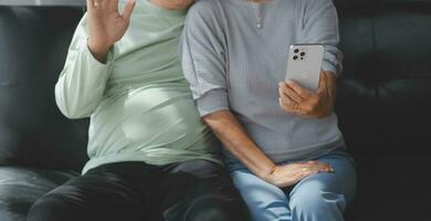 Embraced mature couple surfing the Internet on laptop at home photo