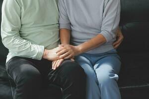 Embraced mature couple surfing the Internet on laptop at home photo