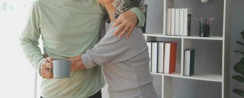 Embraced mature couple surfing the Internet on laptop at home photo