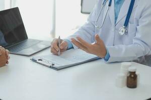 Young doctor visiting elderly woman at home photo