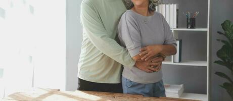 Embraced mature couple surfing the Internet on laptop at home photo