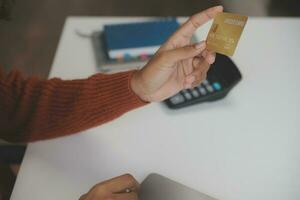 Close up female hands holding credit card and smartphone, young woman paying online, using banking service, entering information, shopping, ordering in internet store, doing secure payment photo