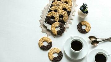 Chocolate cookies with two cups of coffee photo