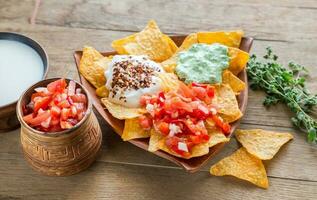 Cheese nachos with different types of sauce photo