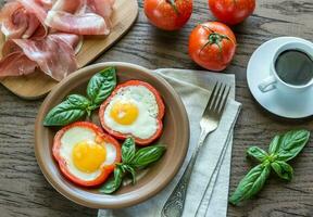 Fried eggs with prosciutto on the wooden table photo