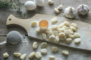 Uncooked potato gnocchi with ingredients photo