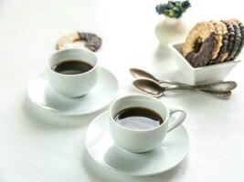Chocolate cookies with two cups of coffee photo