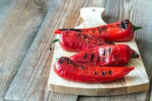 Grilled red peppers on the wooden board photo