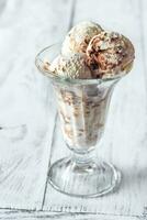 vainilla-chocolate hielo crema en un helado con frutas y nueces vaso foto