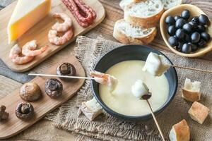 Bowl of fondue with appetizers photo