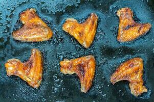 Caramelized chicken wings on the baking tray photo