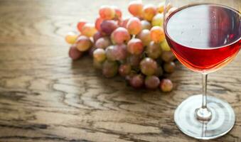 Glass of rose wine with bunch of grape photo