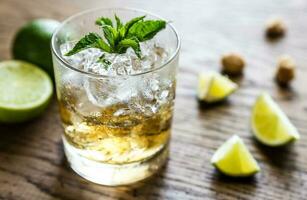 Glass of rum on the wooden background photo