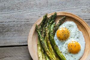 Roasted asparagus with fried eggs photo