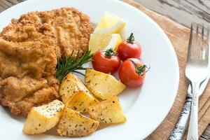 Portion of schnitzel with garnish photo