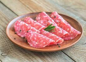 Slices of salami on the plate photo