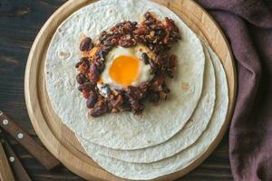 Tortilla with chipotle bean chili and baked egg photo