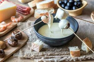 Bowl of fondue with appetizers photo