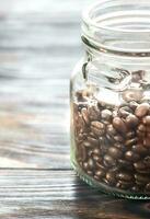 Glass jar of coffee beans photo