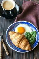 Fried egg with croissant and a cup of coffee photo