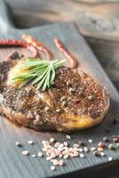 Beef steak with fresh rosemary on the wooden board photo