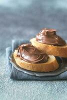 Slice of baguette with chocolate cream on the saucer photo