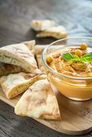 A bowl of hummus with pita slices photo