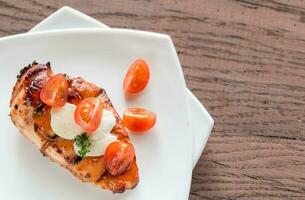 Grilled chicken steak with mozzarella and cherry tomatoes photo