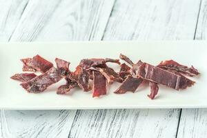 Beef jerky on the white plate photo