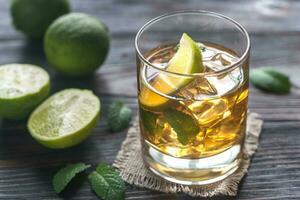 Glass of rum on the wooden background photo