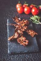 Fried bacon strips on the stone dark board photo