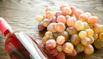 Glass of rose wine with bunch of grape photo