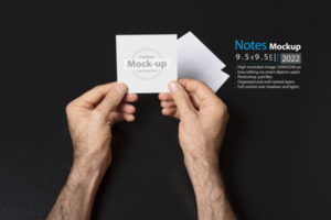 hand holding a blank note paper or image frame on dark background psd