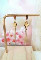 Gold Butterfly Earrings Stud on Jewelry Display Stand photo