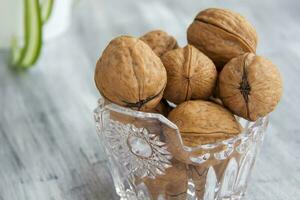 Walnuts on a painted background. Crystal bowl with nuts. Useful products. photo