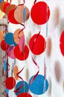 The decor is made of colored paper circles. Color decorative curtain. Decor for the holiday. photo