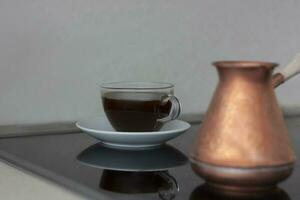 Fragrant black coffee is on the stove. Breakfast with coffee. Make coffee in a turk. Space for the text. photo