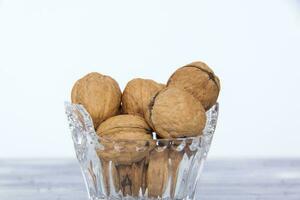 Walnuts in a shell in a crystal vase. Healthy nuts. photo
