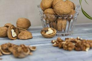 nueces en un pintado antecedentes. cristal cuenco con nueces. útil productos foto