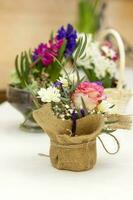 Beautiful flower arrangement in a pot wrapped in burlap. photo