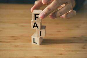 Fail text on wooden cube block on wooden table. business strategy and marketing  concept photo