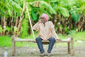 contento indio agricultor. plátano planta, antiguo pobre granjero , trabajador foto