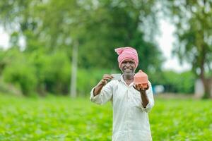 Indian farmer Holding gullak in hand, saving concept, happy poor farmer photo